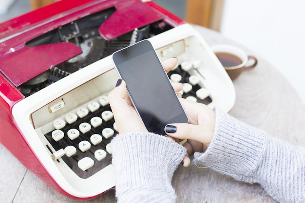 Woman with cell phone and typewriter