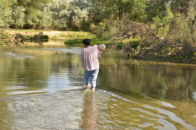 Woman with a child in her arms in the river