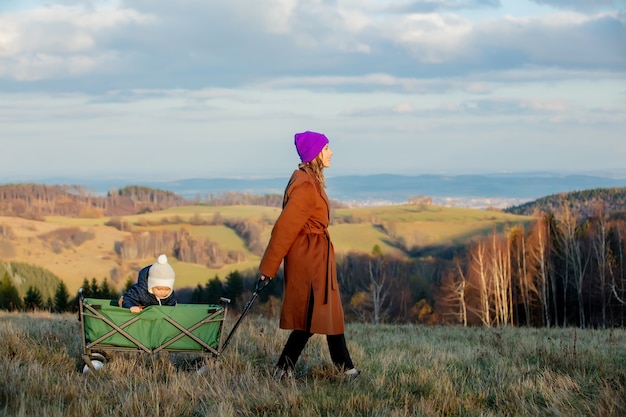 Woman with a child in a wagon in the forest