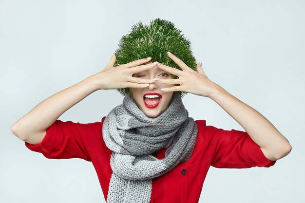 woman with a Christmas decoration on her head on grey