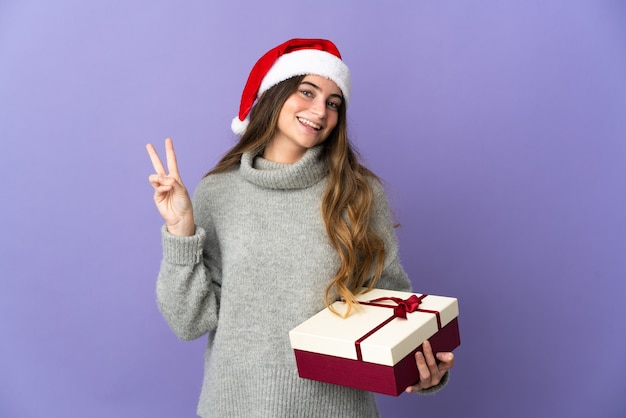 женщина в рождественской шляпе держит подарки