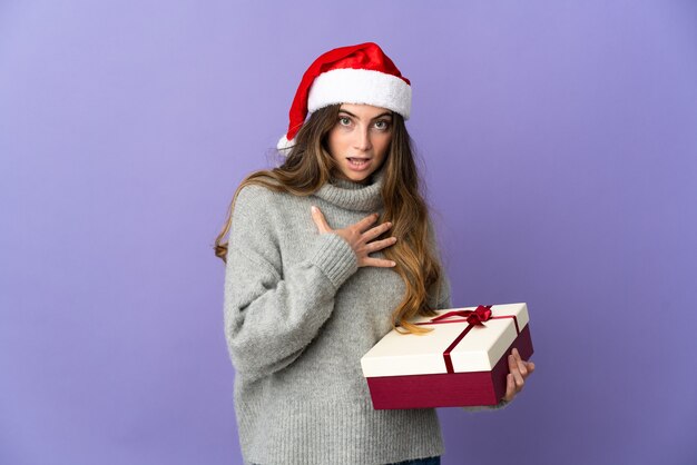 プレゼントを保持しているクリスマスの帽子を持つ女性