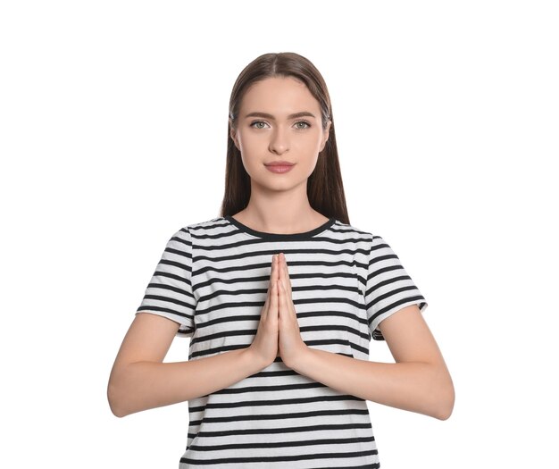 Woman with clasped hands praying on white background