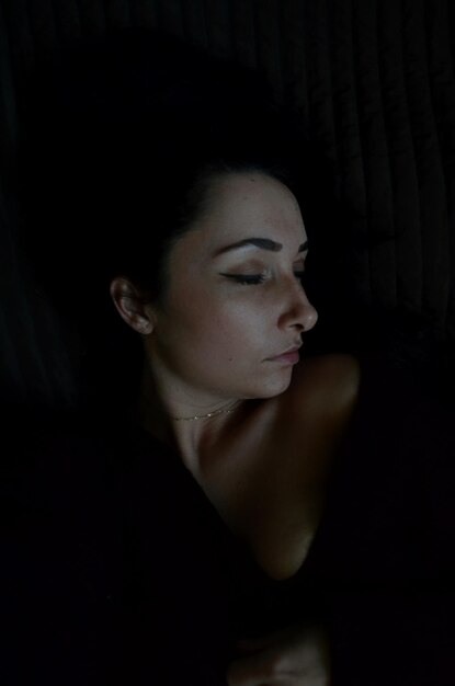Фото Женщина с закрытыми глазами на черном фоне