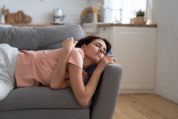Woman with closed eyes lying on pillow resting trying to sleep