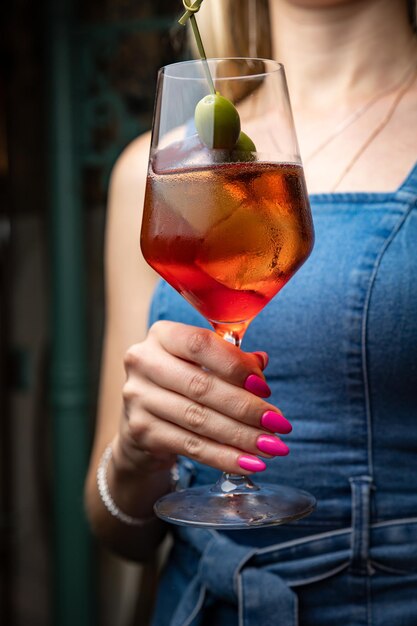 woman with cocktail in hand on a bar counter