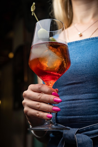 woman with cocktail in hand on a bar counter