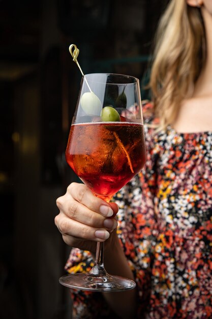 woman with cocktail in hand on a bar counter