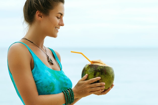 Woman with a coconut drink on the beach