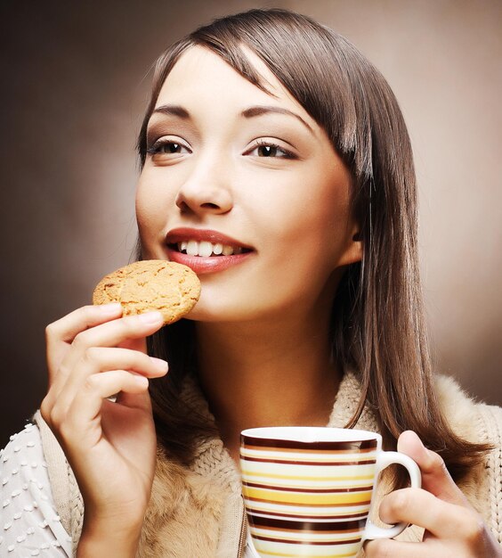 写真 コーヒーとクッキーを持つ女性