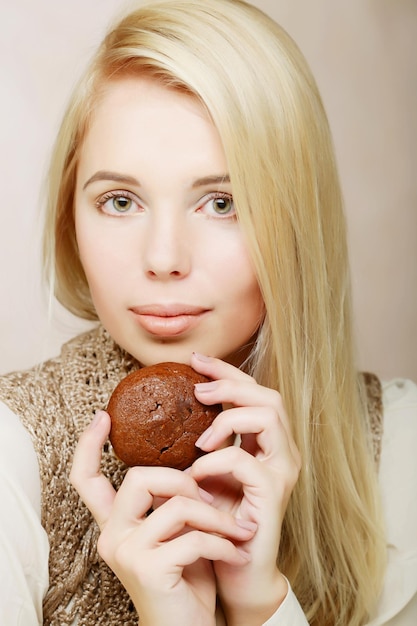 コーヒーとクッキーを持つ女性