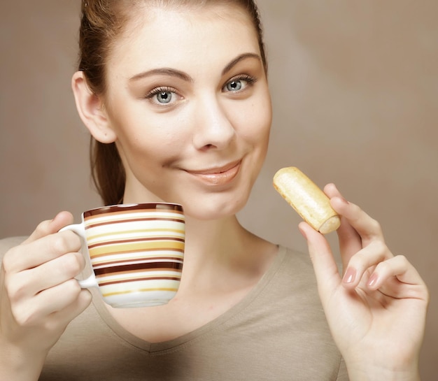 コーヒーとクッキーを持つ女性