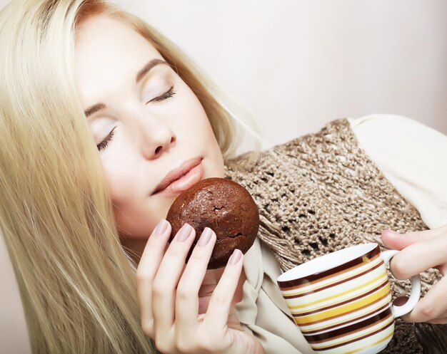 コーヒーとクッキーを持つ女性