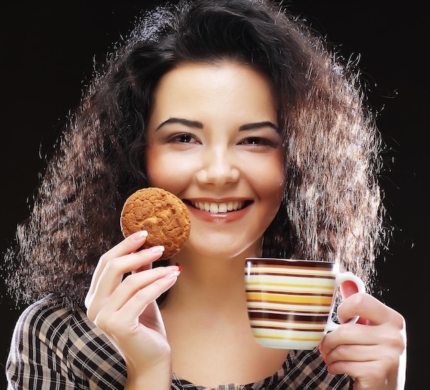 コーヒーとクッキーを持つ女性