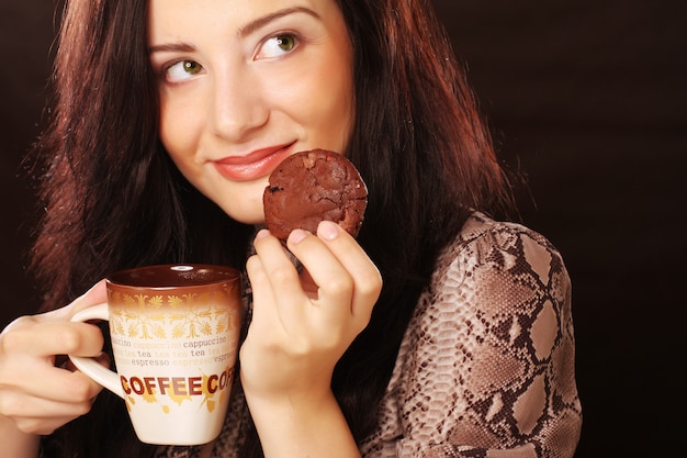 コーヒーとクッキーを持つ女性