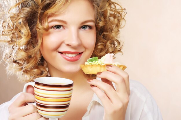 コーヒーとクッキーを持つ女性