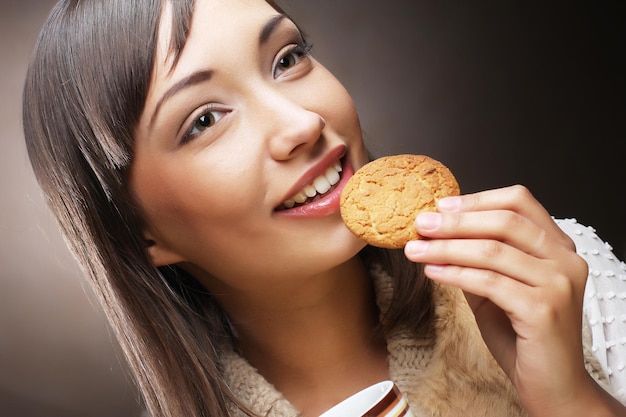 コーヒーとクッキーを持つ女性