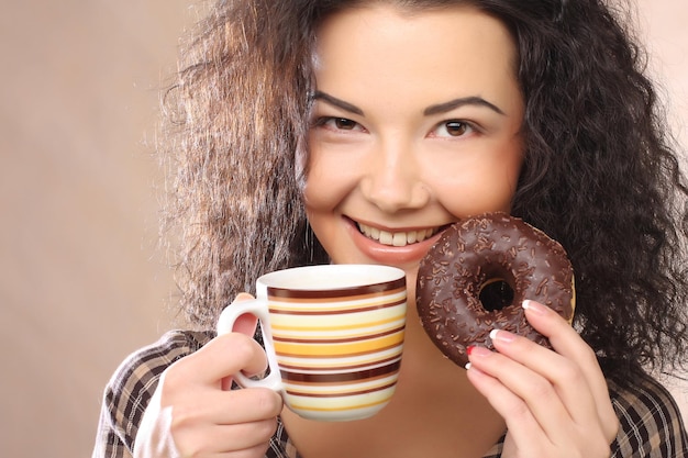 コーヒーとクッキーを持つ女性