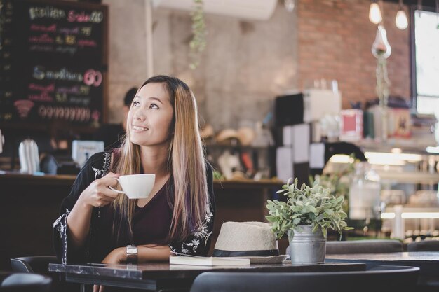 写真 レストランでコーヒーカップを持った女性