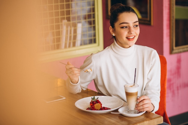 Woman with coffee and dessert in a cafe