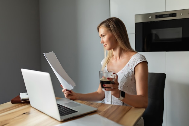 Foto donna con caffè che lavora al computer portatile in ufficio a casa