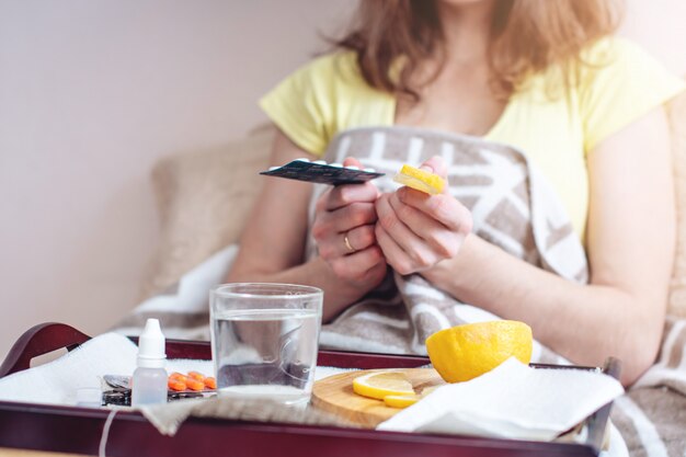 Woman with a cold chooses between pills and vitamins for treatment