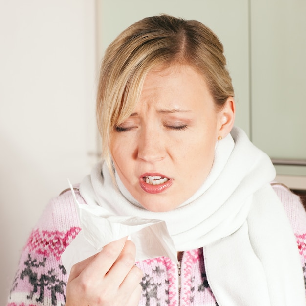 Woman with cold or flu sneezing