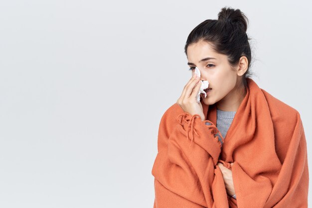 Woman with a cold wipes her nose with a handkerchief flu