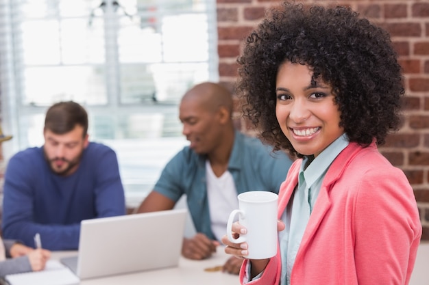 Woman with colleagues behind in office