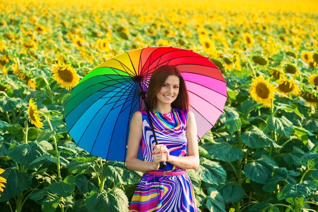 Woman with colorful umbrella in the sunflower fields