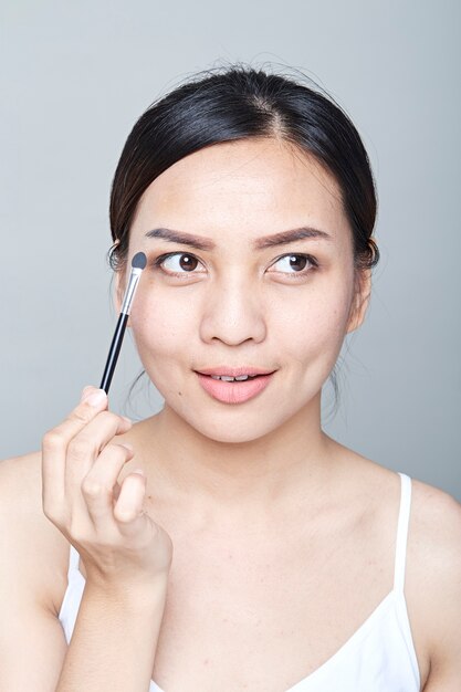 Woman with cosmetics brush