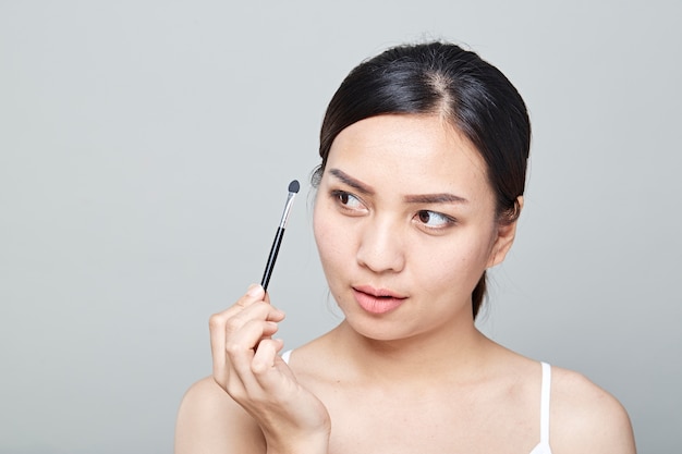 Woman with cosmetics brush