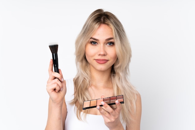 Woman with cosmetics over isolated wall