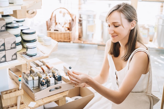 Woman with cotton bag buying personal hygiene items in zero waste shop