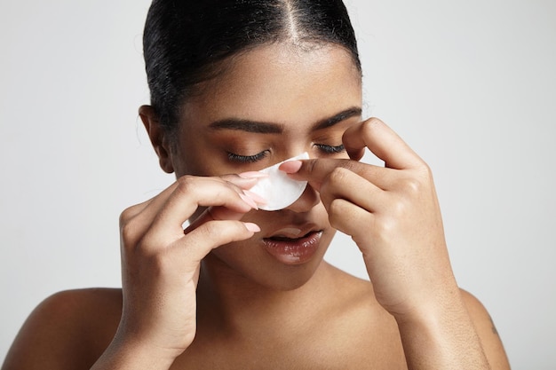 Woman with a cotton pad making facial routine