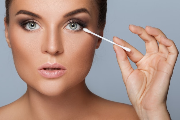 Woman with a cotton swab beside her eye