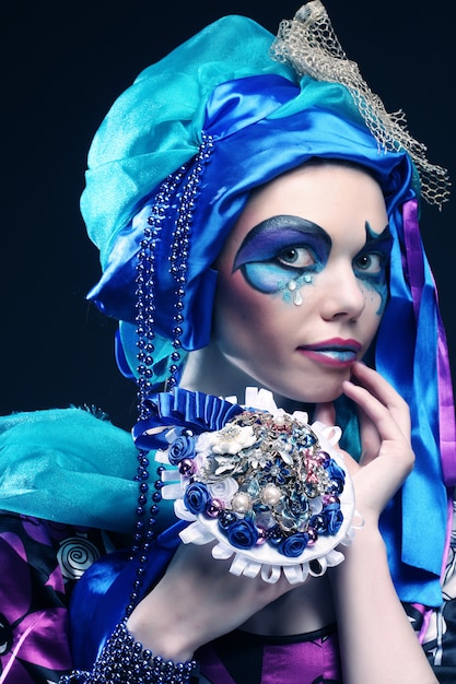 Woman with creative make up holding a bouquet of jewelry