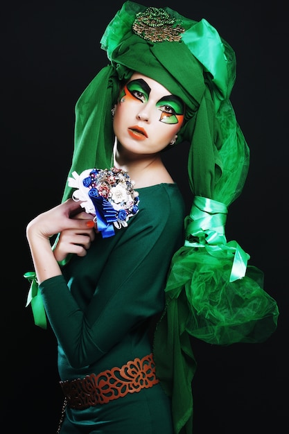 Woman with creative make up holding a bouquet of jewelry