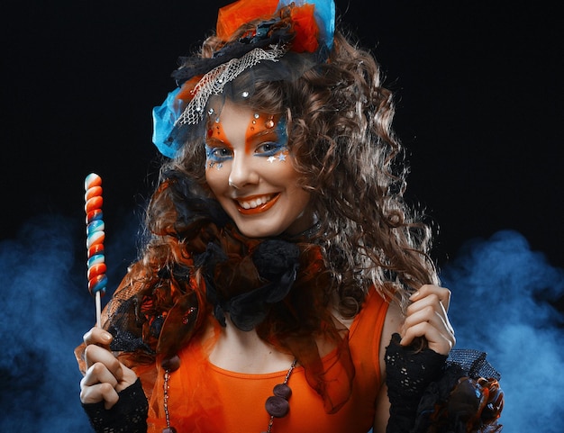 Woman with creative makeup in doll style with candy