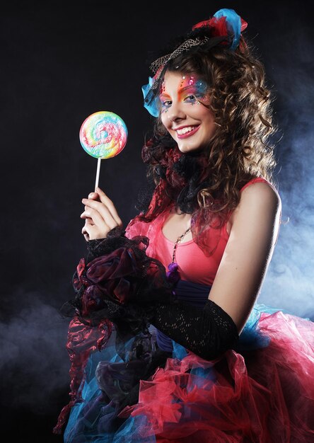 Photo woman with creative makeup in doll style with candy