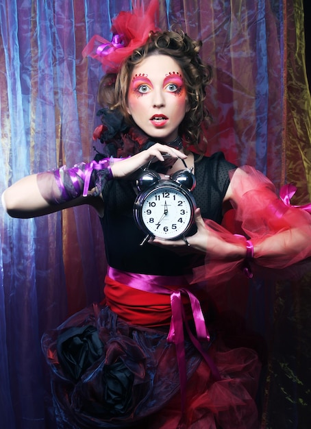 Женщина с креативным макияжем в кукольном стиле с часами