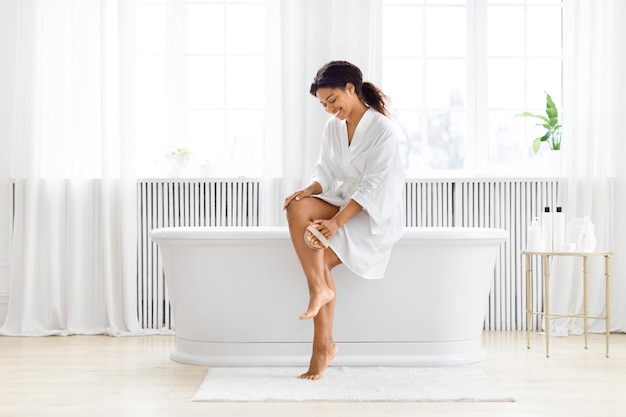 Photo woman with crossed legs sitting at tub edge