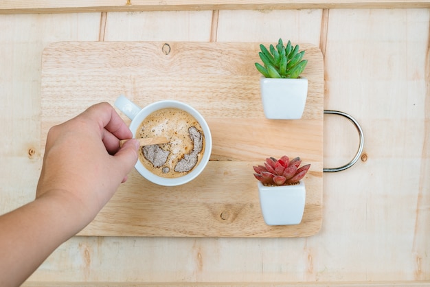 Woman with cup of aromatic coffee on wooden background