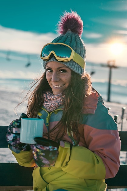 Woman with cup of coffee or tea enjoying the winter day on mountain