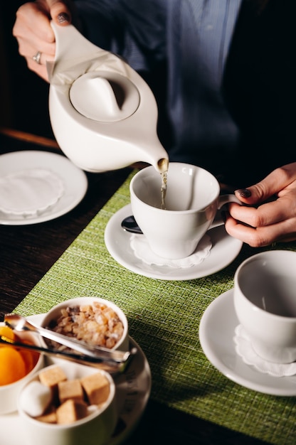 A woman with a cup of hot tea in her hands sits in the restaurant The girl drinks aromatic tea Enjoy the moment take a break