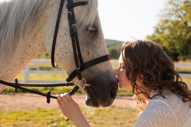 The woman with curly hair huddles to her horse