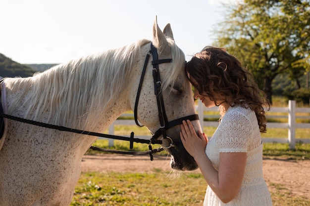 The woman with curly hair huddles to her horse