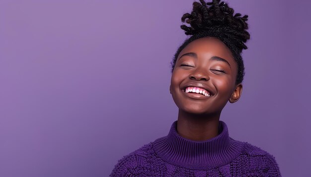 A woman with curly hair is smiling and wearing a purple sweater