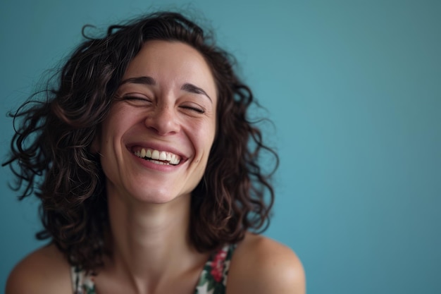 A woman with curly hair laughing and smiling