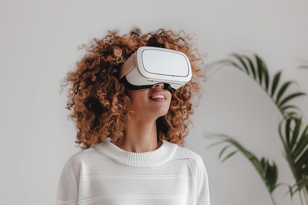 Woman with curly hair looking around in virtual reality goggles in white room